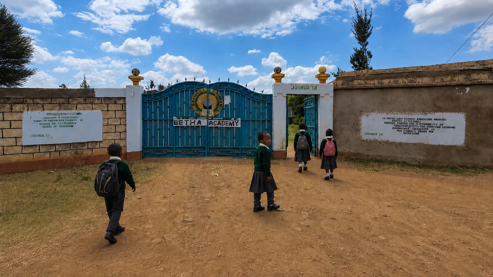 Learners arriving at the main entrance gate of Betha Academy