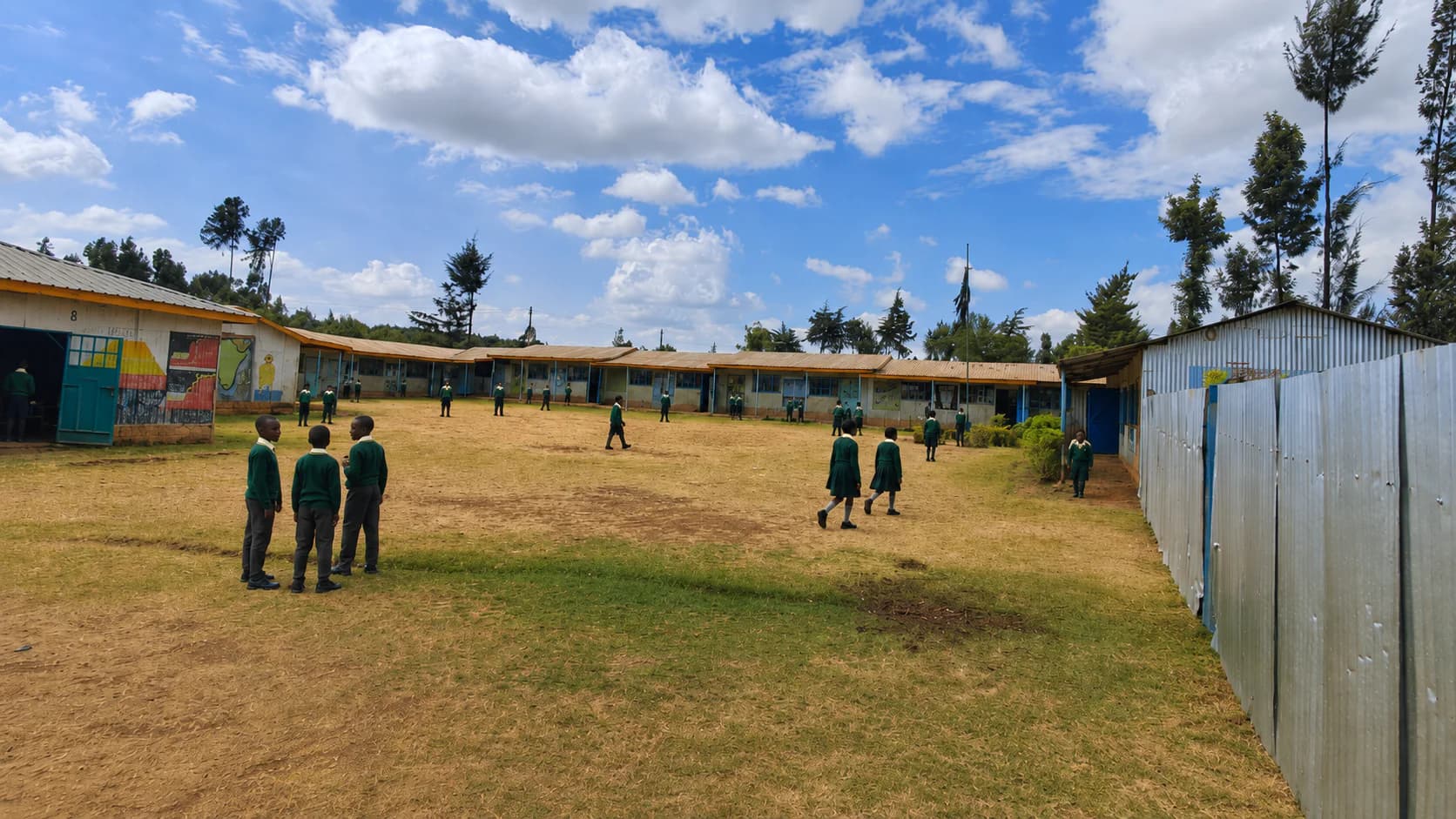 Learners across the Betha Academy grounds in front of the classroom blocks