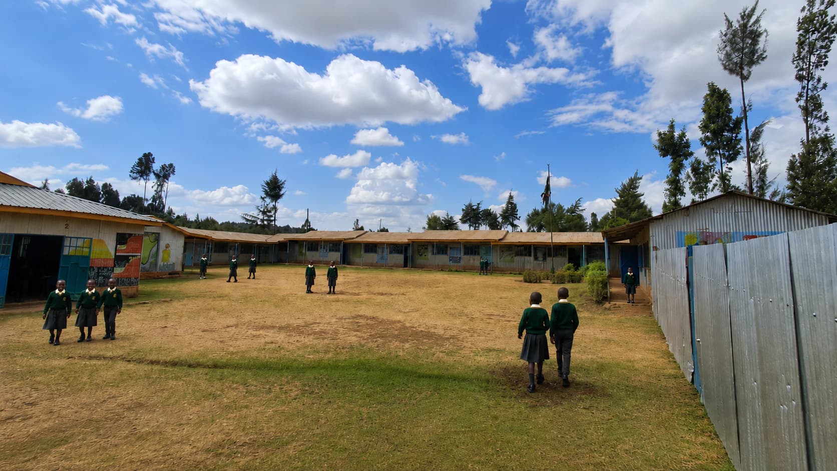Betha Academy learners near the painted classroom blocks